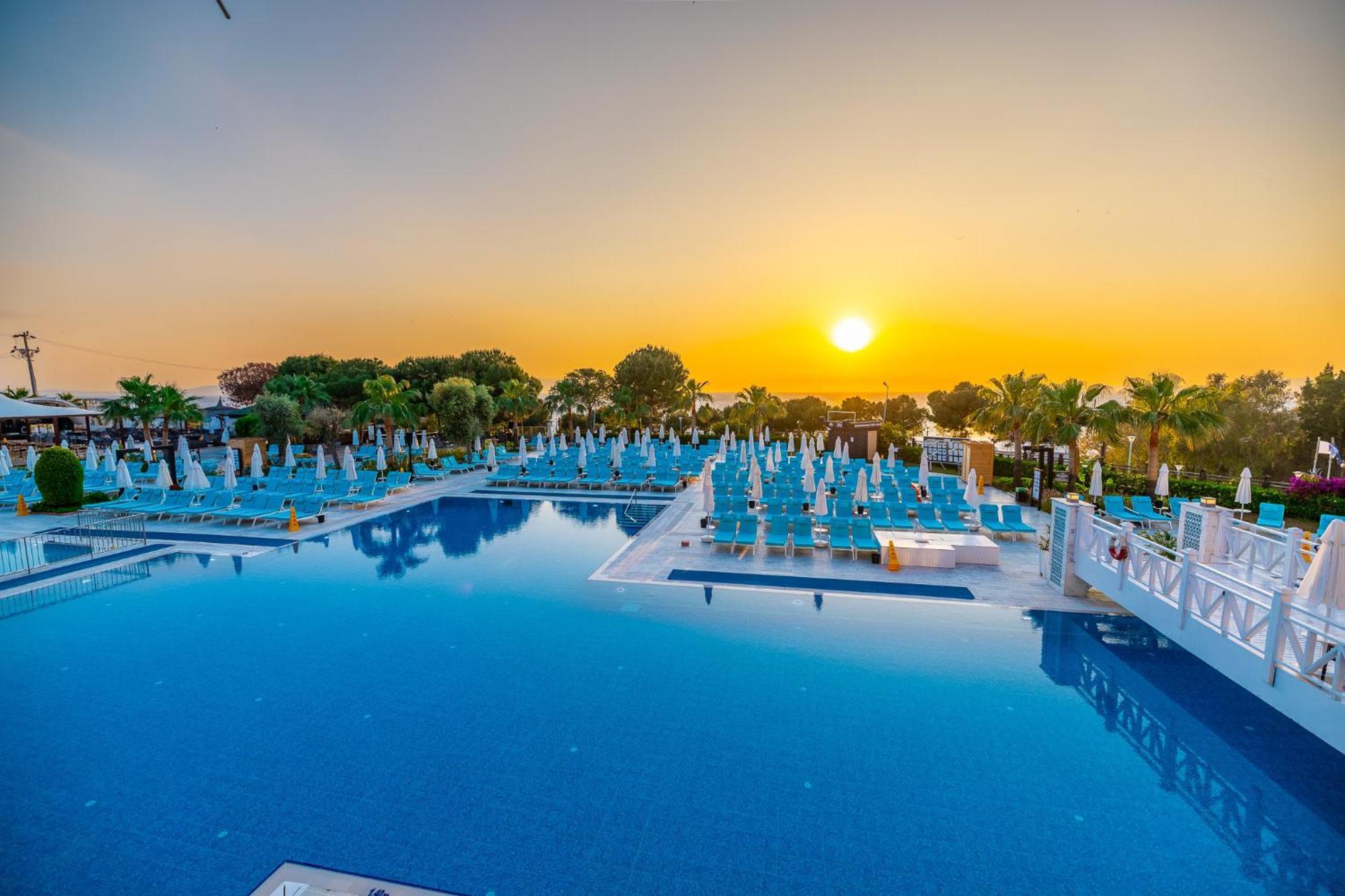 Ramada Resort Kusadasi & Golf Exterior foto Sunset at the pool of the hotel